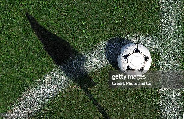 football on grass by pitch marking and shadow of flag - aerial football photos et images de collection