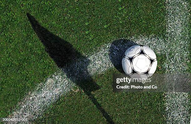 football on grass by pitch marking and shadow of flag - football field stockfoto's en -beelden