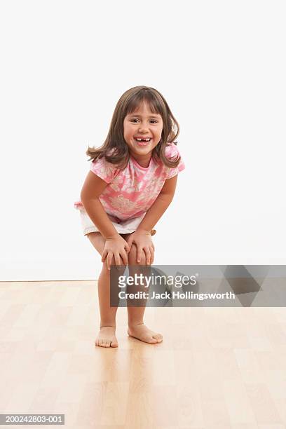 portrait of a girl standing with her hands on her knees - hand on knee fotografías e imágenes de stock