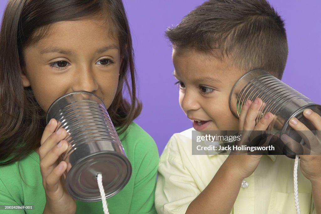 Boy and girl using tin can phones