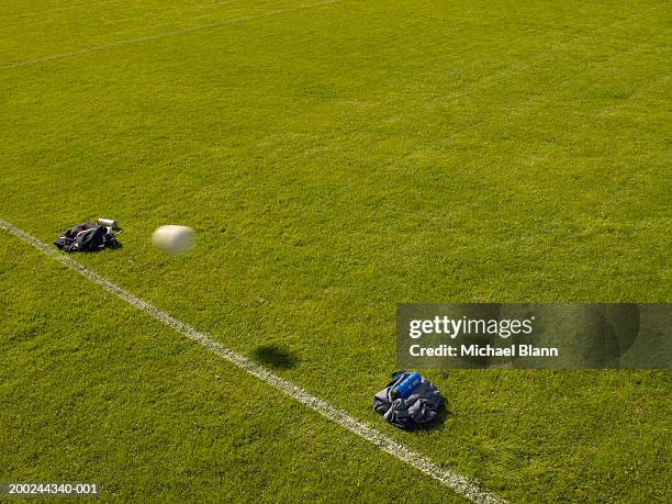 football passing through make-shift goal made with jackets, on pitch - goal posts stockfoto's en -beelden