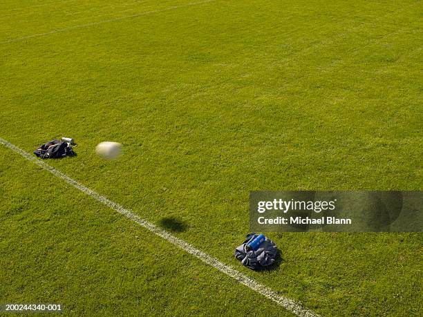 football passing through make-shift goal made with jackets, on pitch - resourceful stock pictures, royalty-free photos & images