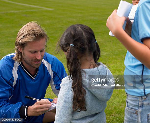 young male footballer signing autograph for girl (5-7), close-up - celebrity children stock pictures, royalty-free photos & images