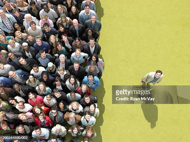 young man standing to side of large crowd looking up, overhead view - afscheid stockfoto's en -beelden
