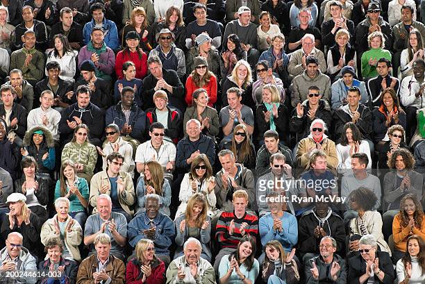 stadium crowd applauding and chatting amongst themselves, full frame - stadium seats stock pictures, royalty-free photos & images