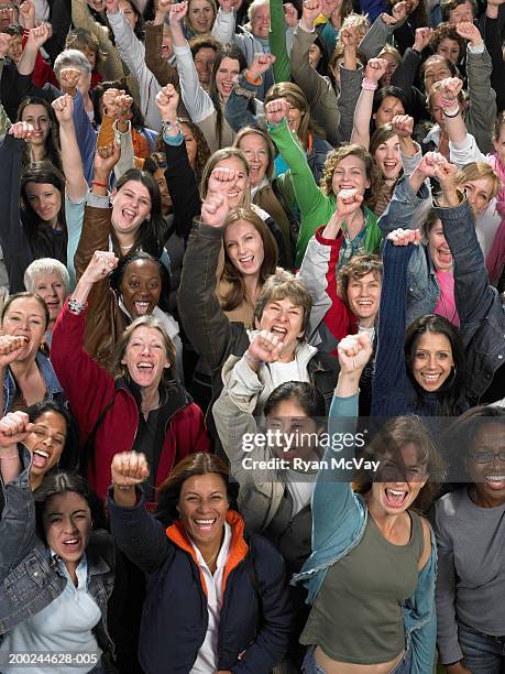 crowd of women cheering and punching air, portrait - droits de la femme photos et images de collection