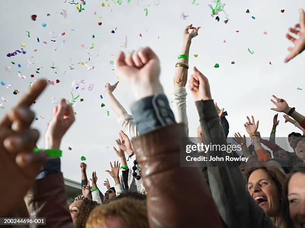 confetti falling over cheering stadium crowd, low angle view - incoraggiamento foto e immagini stock