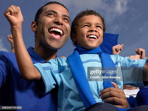 father and son (5-7) in stadium crowd, cheering, close-up - soccer scarf stock pictures, royalty-free photos & images