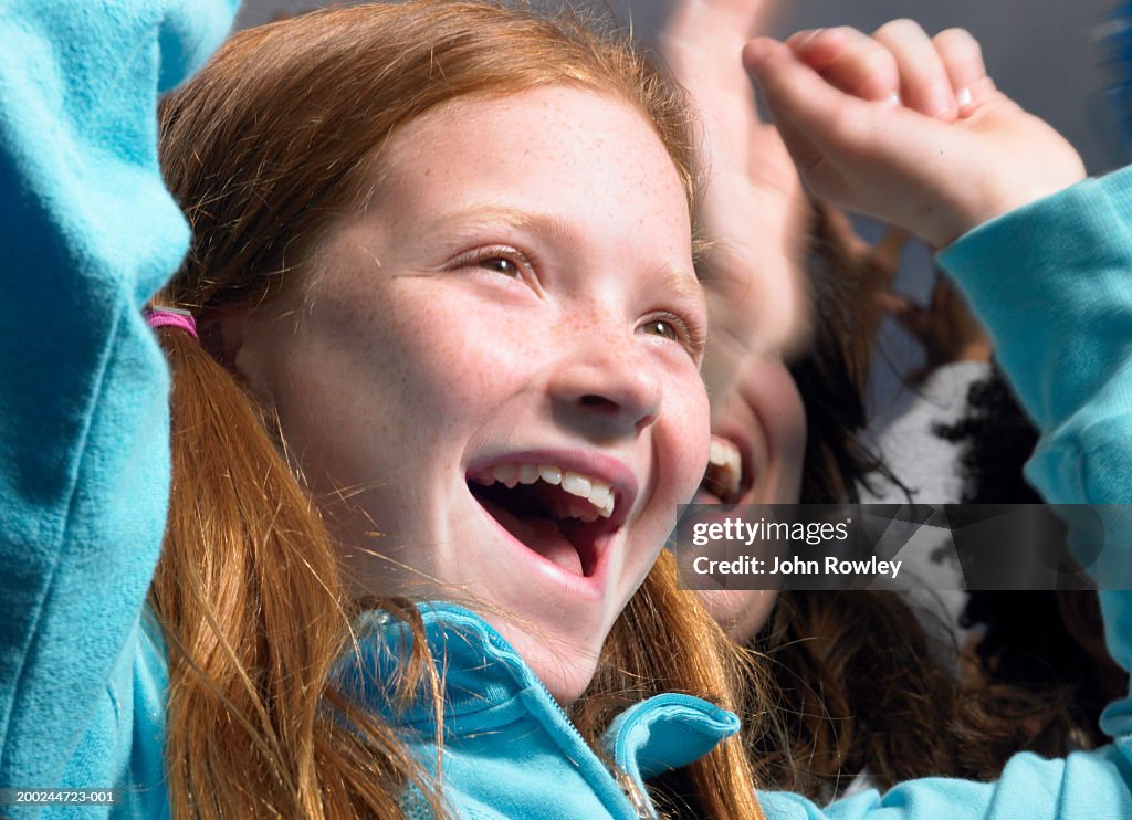 Girl (8-10) in crowd, cheering, close-up