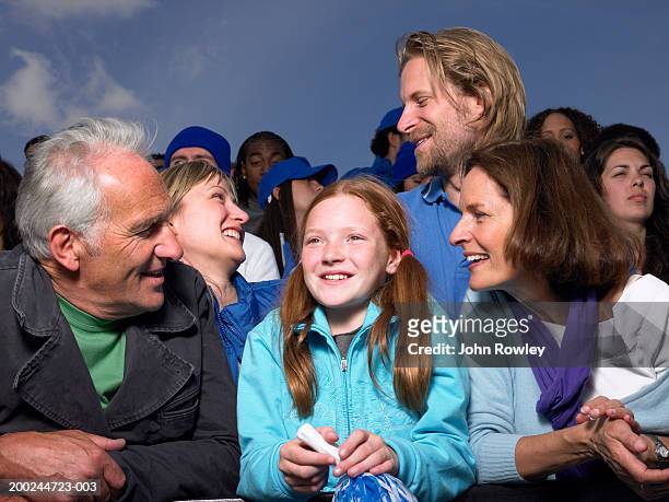 girl (8-10) between grandparents in stadium crowd, close-up - girl who stands stock pictures, royalty-free photos & images