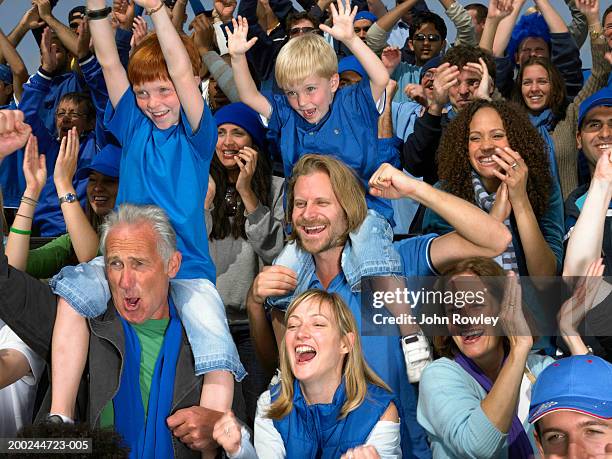 stadium crowd cheering, boys (5-9) sitting on men's shoulders, waving - spectator parent stock pictures, royalty-free photos & images