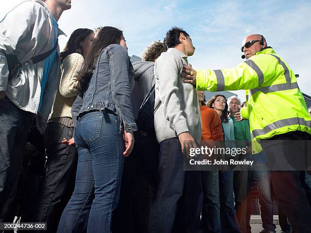 security guard holding back crowd, low angle view - wachmann stock-fotos und bilder