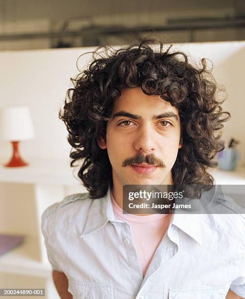 young man with curly hair and moustache, portrait, close-up - moustaches stock-fotos und bilder