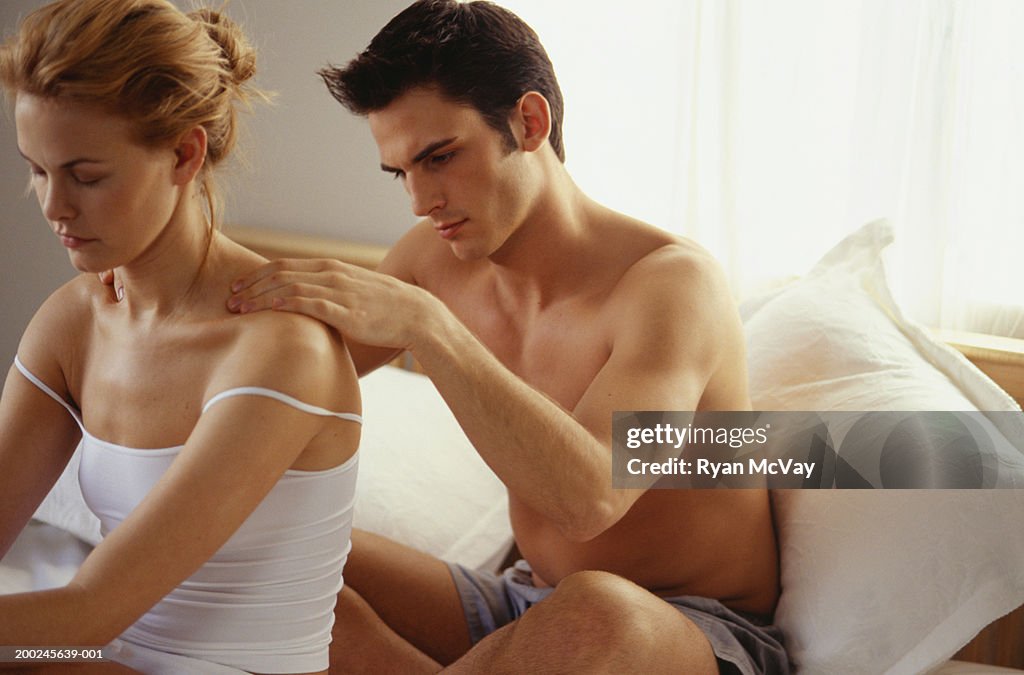 Couple sitting in Bed, Man Massaging shoulders of woman