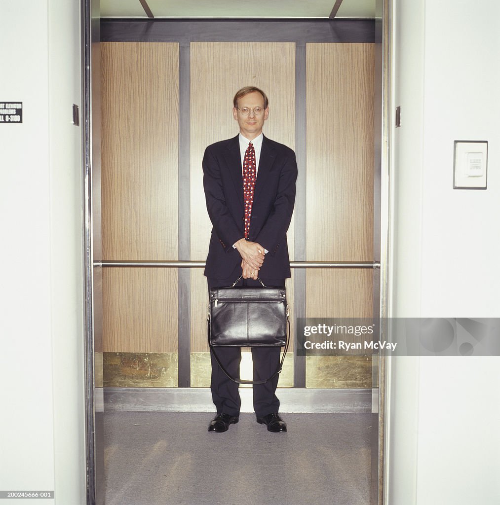 Mature businessman standing in elevator