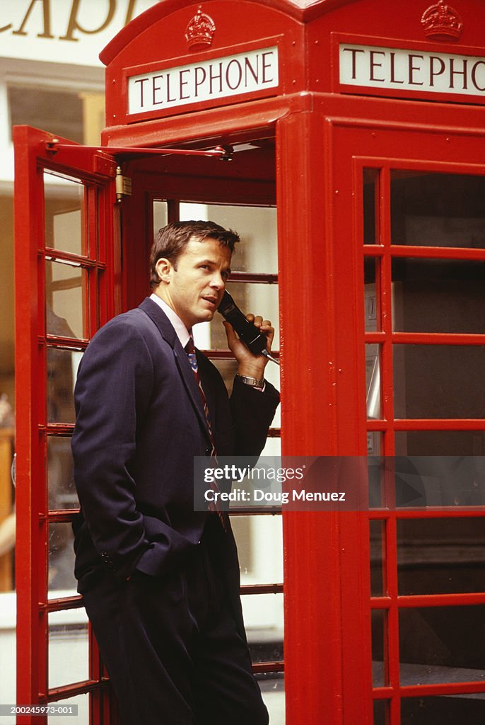 Businessman in red phone booth