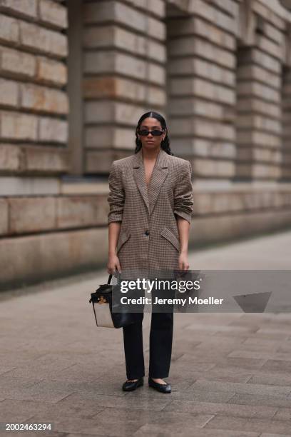 Cherifa Akili seen wearing YSL black sunglasses, gold earrings, Yes My Love beige / black houndstooth pattern elegant blazer jacket, Khaite black...