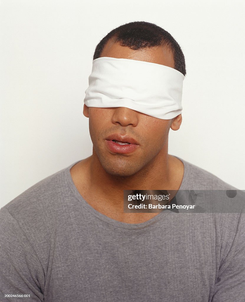 Man blindfolded, posing in studio, (Portrait)
