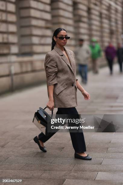 Cherifa Akili seen wearing YSL black sunglasses, gold earrings, Yes My Love beige / black houndstooth pattern elegant blazer jacket, Khaite black...