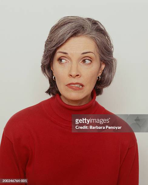 woman in red jumper, (portrait) - female biting lips stockfoto's en -beelden