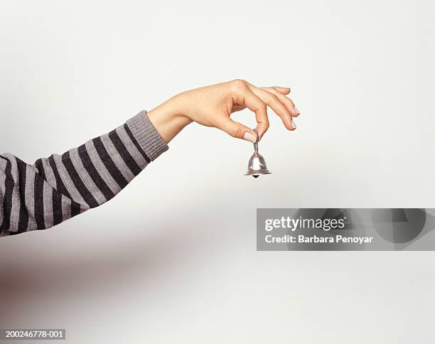 woman ringing little bell, close-up of hand - sleeve stock-fotos und bilder