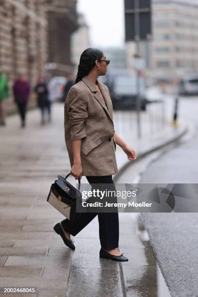 Cherifa Akili seen wearing YSL black sunglasses, gold earrings, Yes My Love beige / black houndstooth pattern elegant blazer jacket, Khaite black...