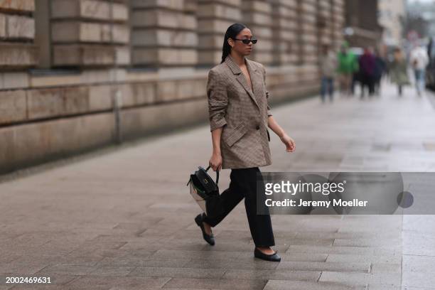 Cherifa Akili seen wearing YSL black sunglasses, gold earrings, Yes My Love beige / black houndstooth pattern elegant blazer jacket, Khaite black...