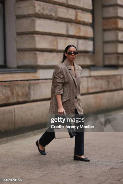 Cherifa Akili seen wearing YSL black sunglasses, gold earrings, Yes My Love beige / black houndstooth pattern elegant blazer jacket, Khaite black...