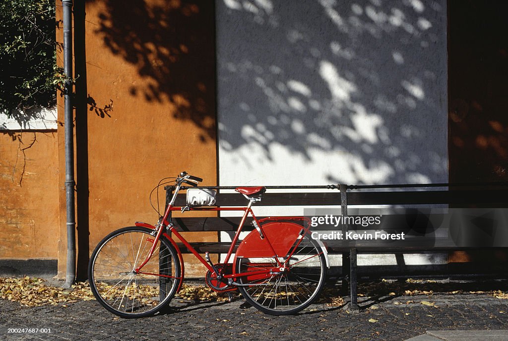 Red bike resting against bench, Copenhagen, Denmark