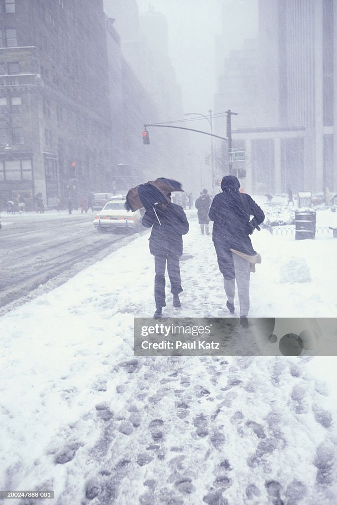 People walking in street in snowstorm, NYC, NY, USA