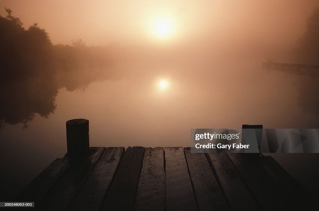 Wooden jetty on lake at sunset, New Orleans, LA, USA