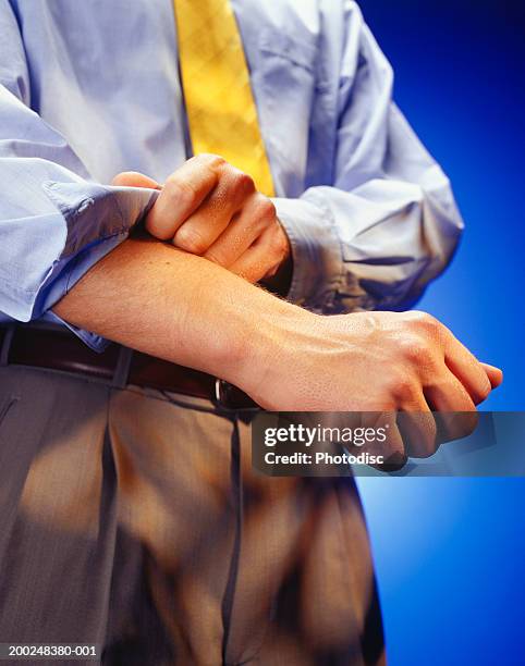 man rolling up sleeves, mid section, (close-up) - sleeve roll stock pictures, royalty-free photos & images