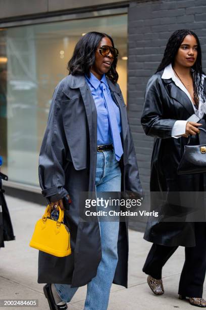 Guest wears grey trench coat, yellow bag outside Proenza Schouler on February 10, 2024 in New York City.