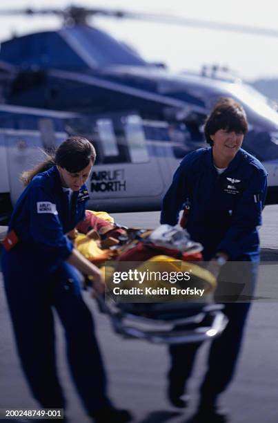 nurses carrying patient on stretcher from helicopter - elicottero-ambulanza foto e immagini stock
