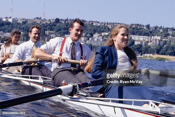four businesspeople rowing in city bay - team rowing boat in bay stock pictures, royalty-free photos & images