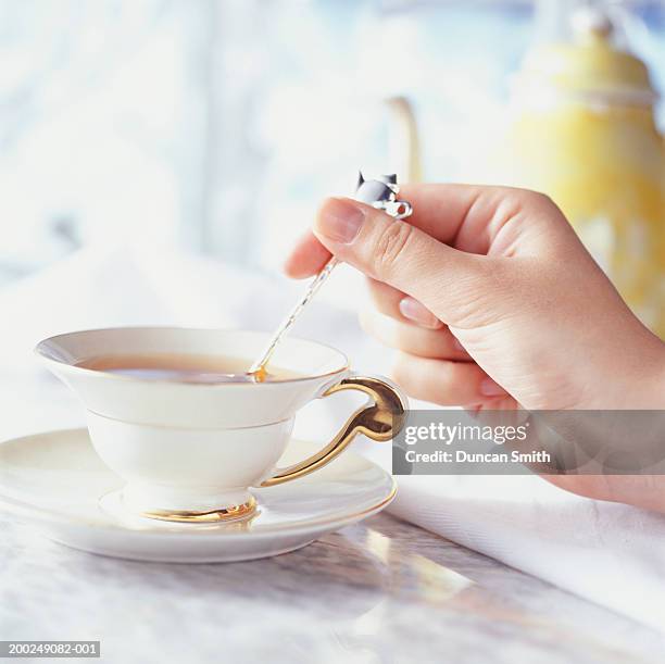 woman stirring tea with teaspoon, close-up of hand, (close-up) - spoon in hand ストックフォトと画像