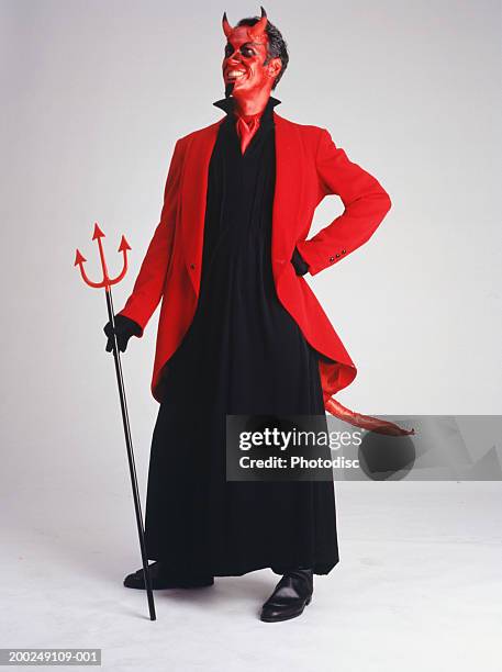 man in devil costume standing, smiling - pitchfork stock pictures, royalty-free photos & images