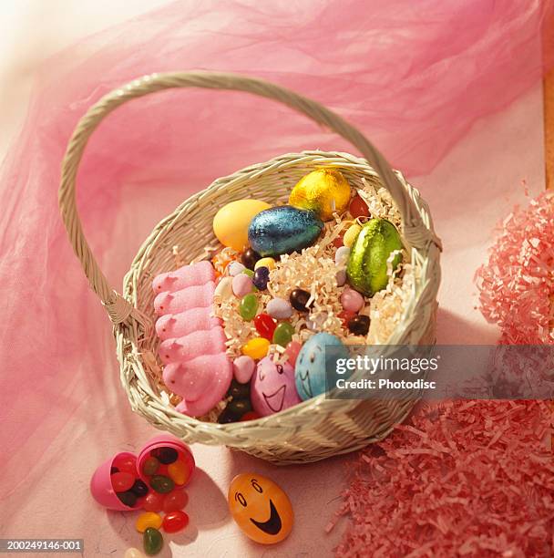 easter basket of assorted eggs on pink background - easter basket with candy stock pictures, royalty-free photos & images