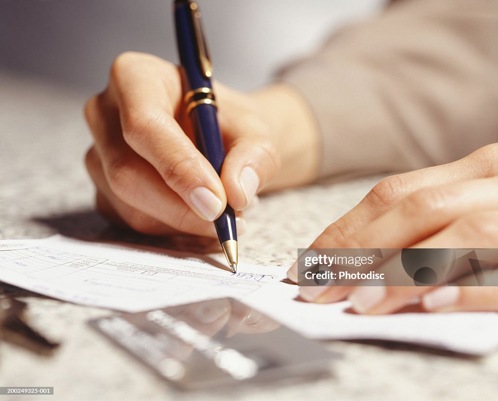 Woman signing receipt, Close-up of hands