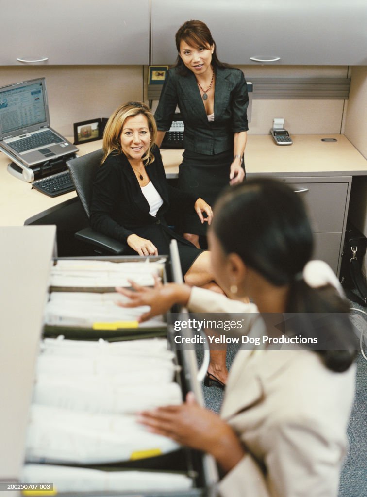 Three businesswomen in office cubicle, elevated view