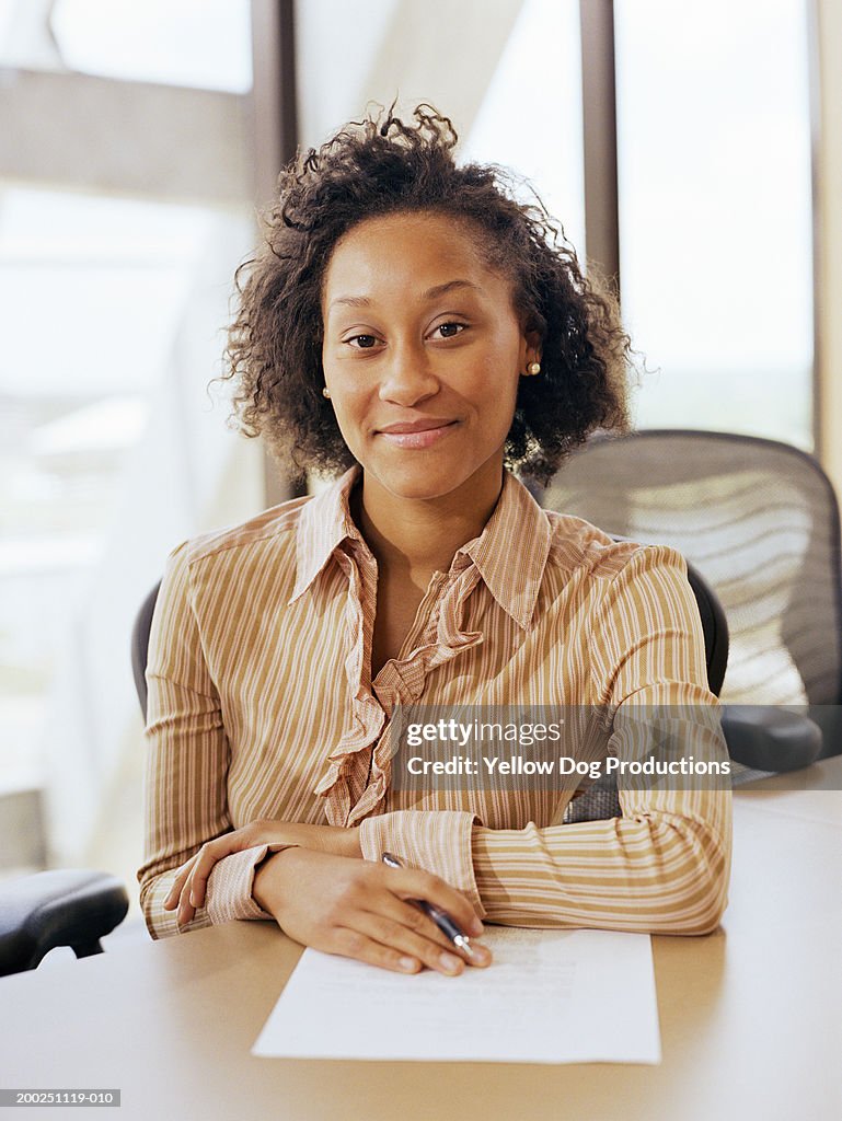 Young businesswoman sitting at conference room, portrait