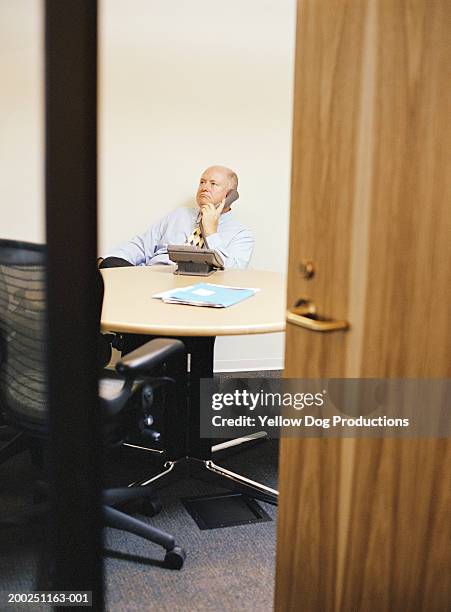 businessman using phone in boardroom - door ajar stock pictures, royalty-free photos & images