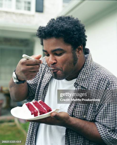 man eating cake in yard, close-up - comfort food fotografías e imágenes de stock