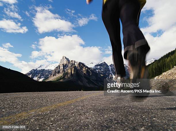 mature woman running on mountain road, low section (blurred motion) - woman jogging pants stock pictures, royalty-free photos & images