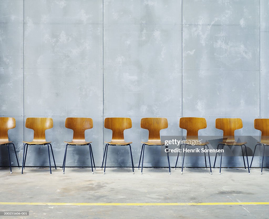 Row of empty chairs against wall