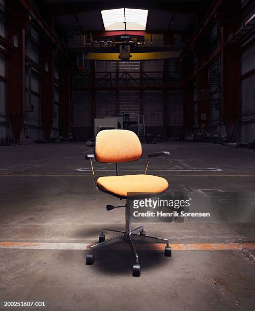 office chair under spotlight in empty warehouse - スポットライト　無人 ストックフォトと画像