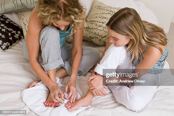 mother painting daughter's (13-15) toes with nail polish - teenage girls barefoot stock pictures, royalty-free photos & images