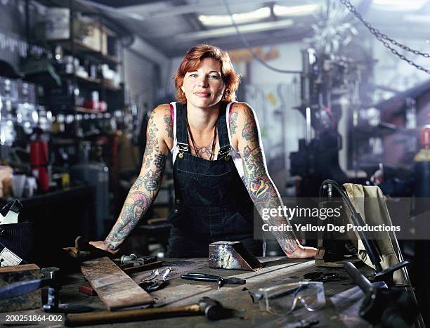 woman with tattoos in both arms in factory, portrait - welder photos et images de collection