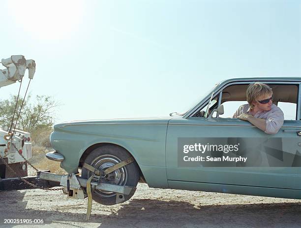 young man in car being towed by truck - road assistance stock pictures, royalty-free photos & images