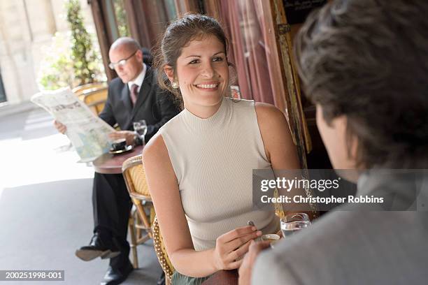 woman sitting with man at outdoor cafe, smiling (focus on woman) - business lunch outside stock pictures, royalty-free photos & images